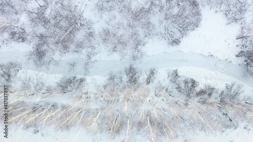 Flight over small frozen winter river. Top down view with fisheye effect