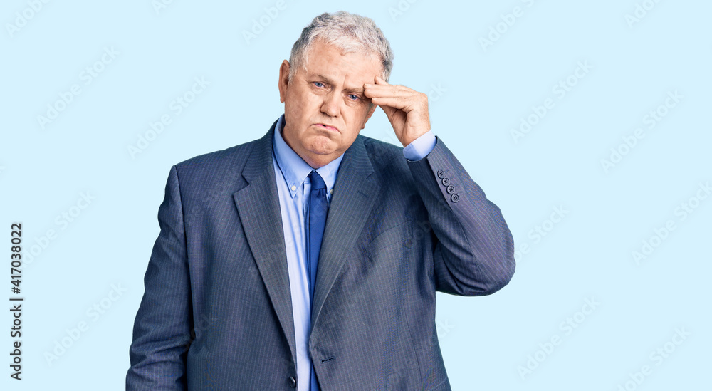Senior grey-haired man wearing business jacket worried and stressed about a problem with hand on forehead, nervous and anxious for crisis Senior grey-haired man wearing business jacket worried and stressed about a problem with hand on forehead, nervous and anxious for crisis