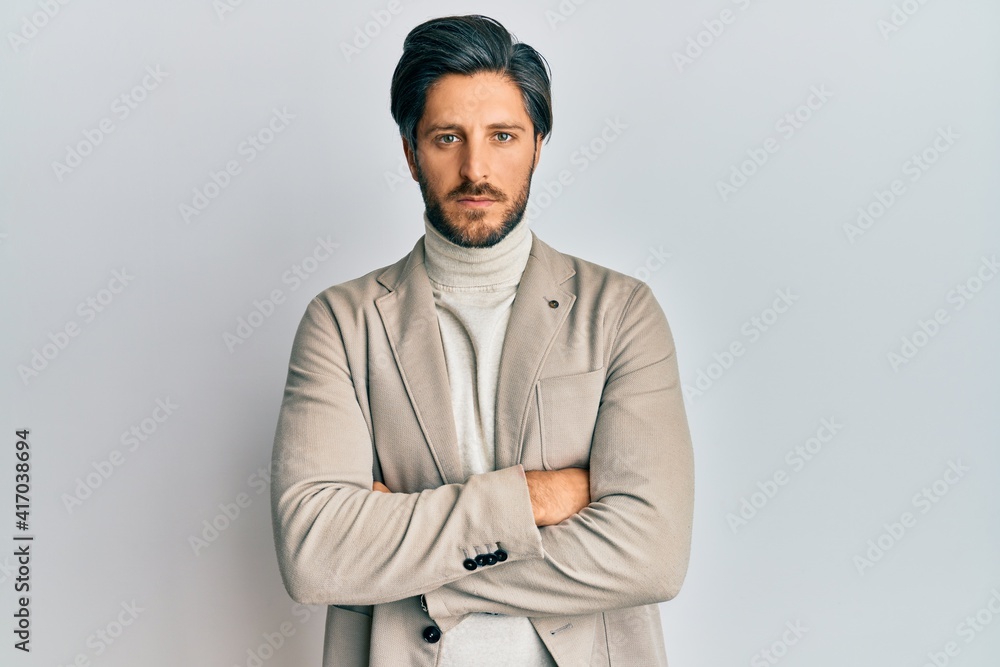 Fototapeta premium Young hispanic man with arms crossed gesture relaxed with serious expression on face. simple and natural looking at the camera.