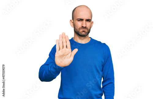 Young hispanic man wearing casual clothes doing stop sing with palm of the hand. warning expression with negative and serious gesture on the face.
