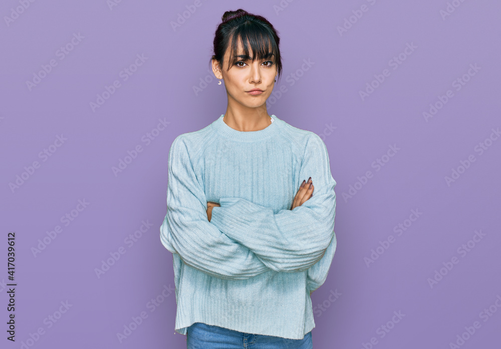 Young hispanic woman wearing casual clothes skeptic and nervous, disapproving expression on face with crossed arms. negative person.
