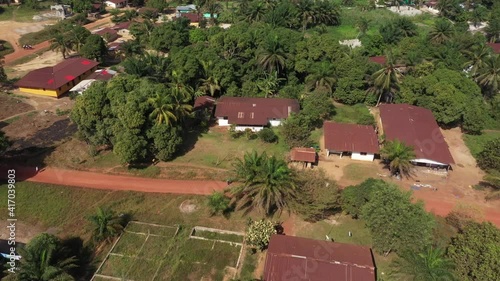 Aerial Kakata village tropical homes Liberia Africa. Homes, business and nature near Monrovia Liberia. Tropical forest landscape. Poor low income poverty environment. Trees, roads and path photo