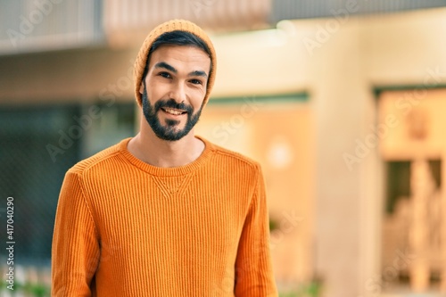 Young hispanic man wearing winter style smiling happy at the city.