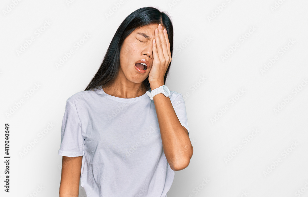 Beautiful young asian woman wearing casual white t shirt yawning tired covering half face, eye and mouth with hand. face hurts in pain. Beautiful young asian woman wearing casual white t shirt yawning tired covering half face, eye and mouth with hand. face hurts in pain.
