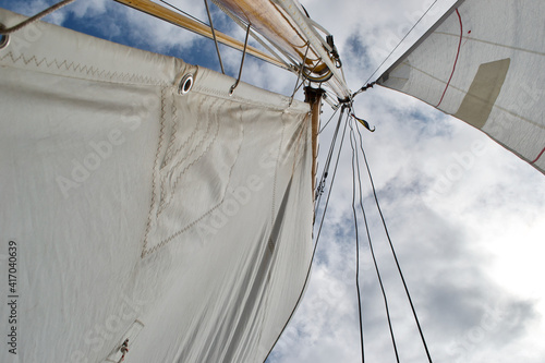 Photos Looking up the mast of a gaff rigged sailing yacht: white sails, wooden mast and