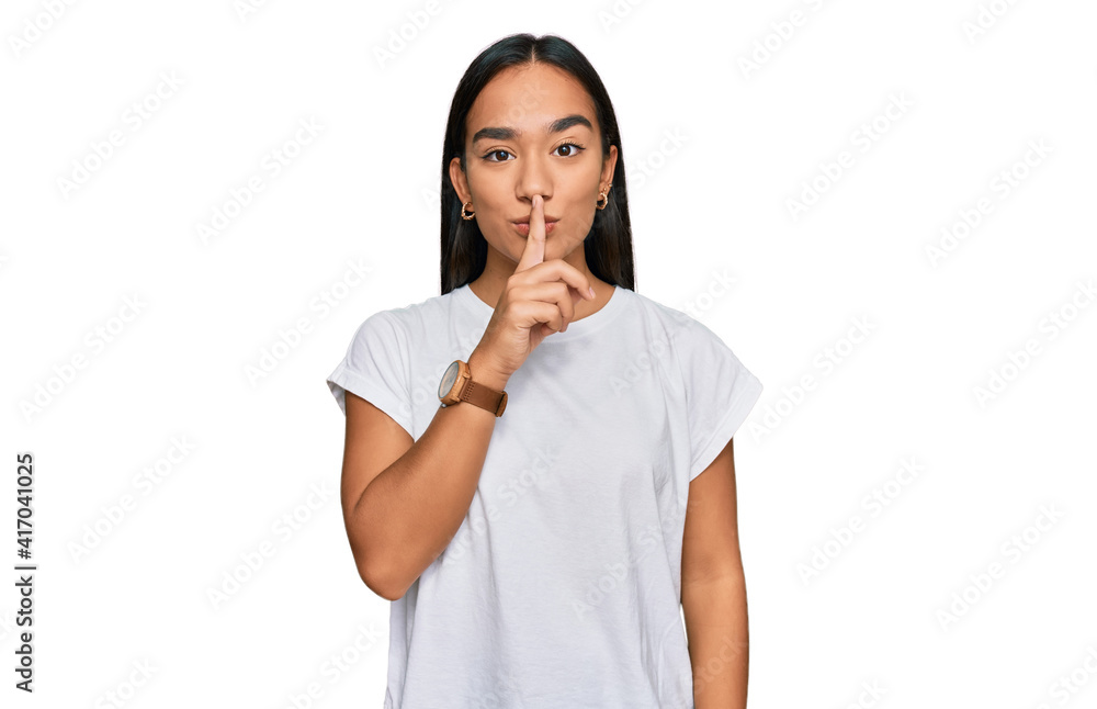 Young asian woman wearing casual white t shirt asking to be quiet with finger on lips. silence and secret concept. Young asian woman wearing casual white t shirt asking to be quiet with finger on lips. silence and secret concept.