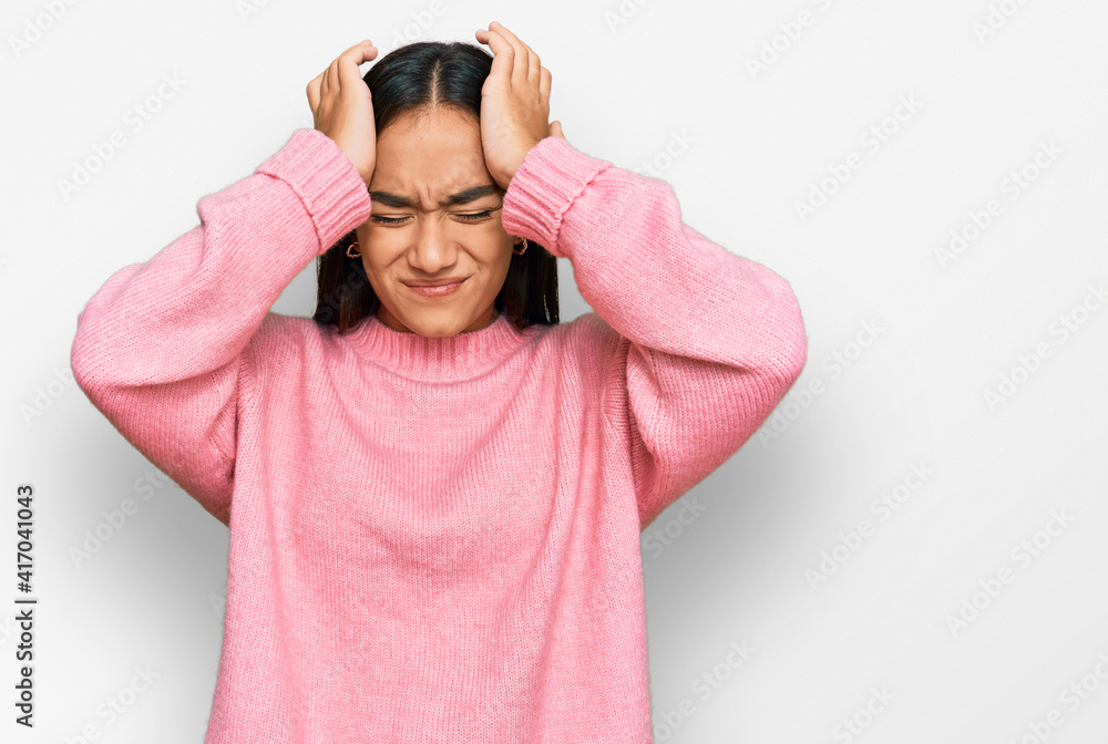 Young asian woman wearing casual winter sweater suffering from headache desperate and stressed because pain and migraine. hands on head. Young asian woman wearing casual winter sweater suffering from headache desperate and stressed because pain and migraine. hands on head.