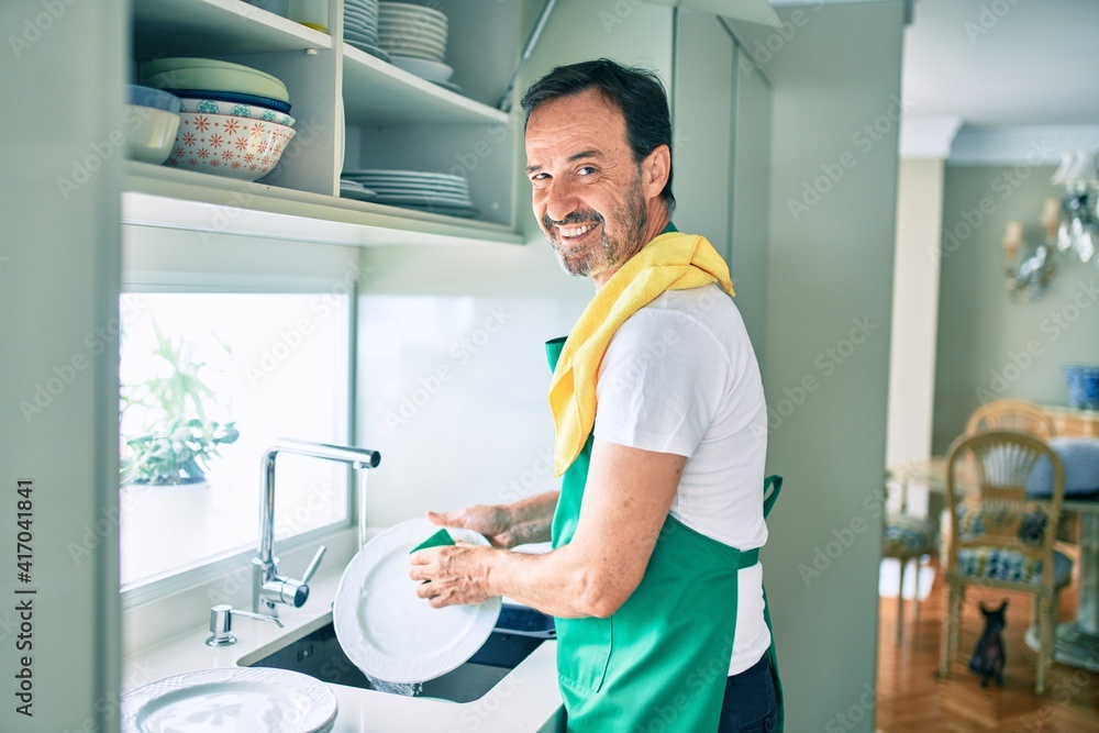 Middle age man with beard smiling happy washing dishes at home Middle age man with beard smiling happy washing dishes at home