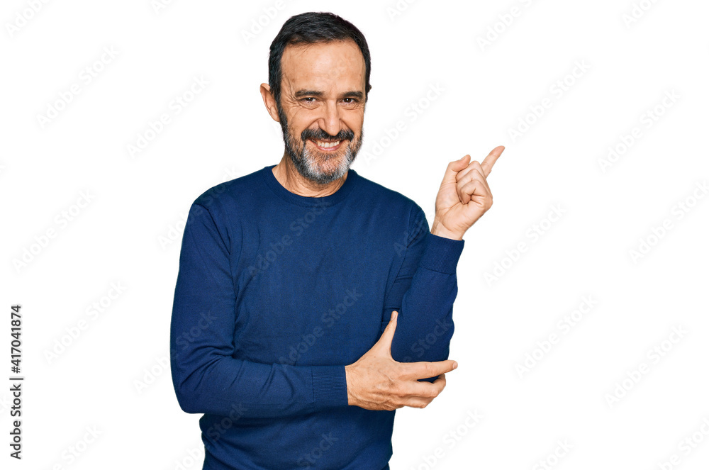 Middle age hispanic man wearing casual clothes with a big smile on face, pointing with hand and finger to the side looking at the camera. Middle age hispanic man wearing casual clothes with a big smile on face, pointing with hand and finger to the side looking at the camera.