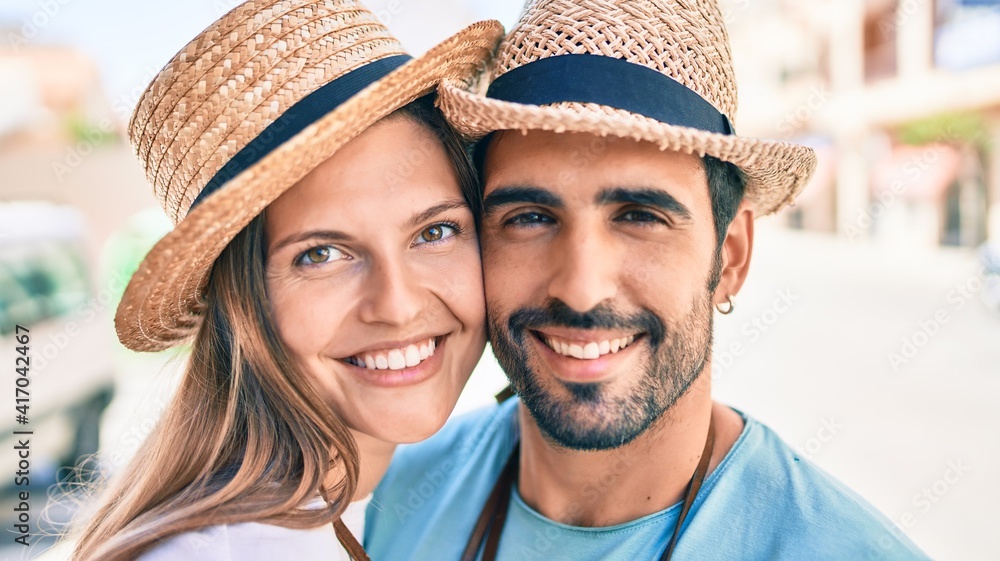 Young couple of boyfriend and girlfriend tourists on a summer trip wearing summer hat