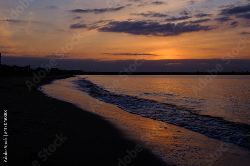 明け方の須磨浦海浜公園。厚い雲に覆われ太陽はまだ顔を出さないが、雲と砂浜をオレンジ色に染める。