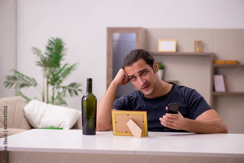 Young male alcoholic suffering from unhappy love at home Young male alcoholic suffering from unhappy love at home
