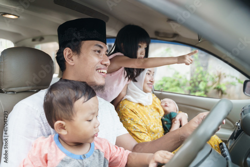 Muslim family travel by car during eid mubarak celebration. asian people going back to their hometown