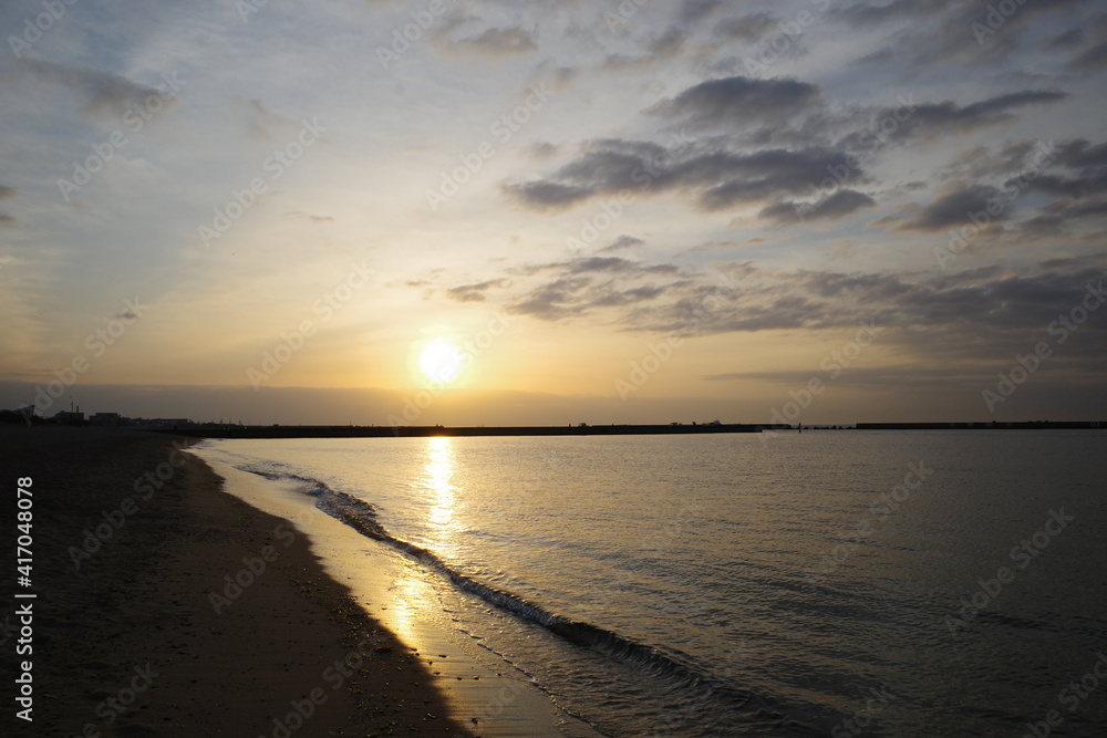朝日が昇る須磨浦海浜公園の夜明け。雲と海がオレンジ色に染まる。