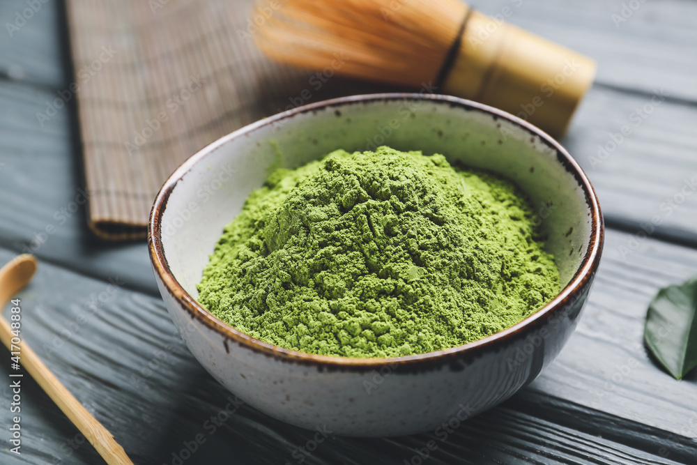 Bowl with powdered matcha tea on dark wooden background, closeup Bowl with powdered matcha tea on dark wooden background, closeup