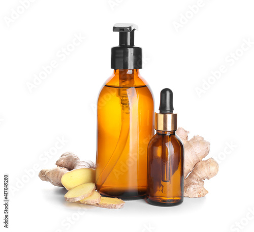 Bottles with ginger essential oil on white background