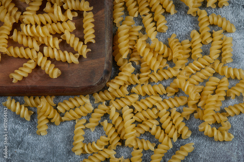 Scattered raw pasta on blue background