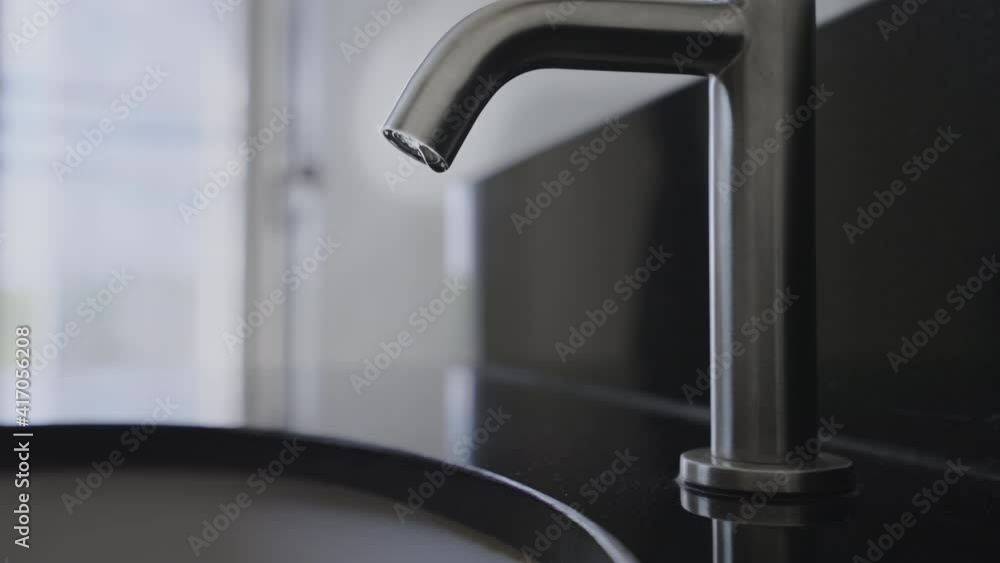 Close up wash basin water drop in bathroom, Stainless steel water tap or water vale have water drop,Slow motion water drop chrome faucet in the toilet,Concept save water energy and protect environment Close up wash basin water drop in bathroom, Stainless steel water tap or water vale have water drop,Slow motion water drop chrome faucet in the toilet,Concept save water energy and protect environment