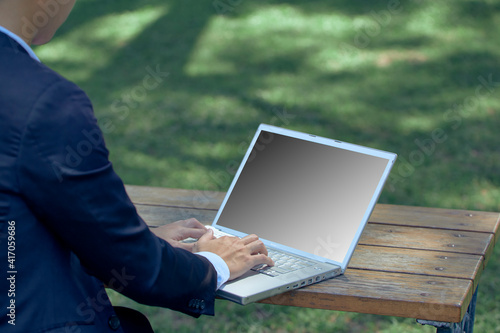 Young man using laptop at the park