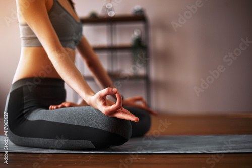 Beautiful young woman practicing yoga in the lotus position