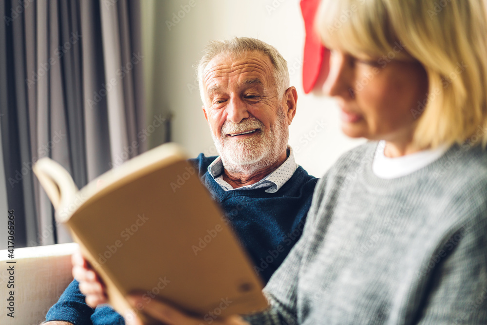 Senior couple family relax having good time reading the book together.Happy elderly husband and wife reading news and magazine while sitting on sofa at home.Retirement concept Senior couple family relax having good time reading the book together.Happy elderly husband and wife reading news and magazine while sitting on sofa at home.Retirement concept