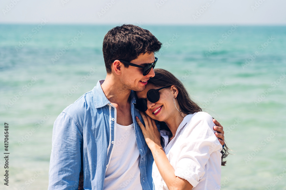 Vacation romantic lovers young happy couple hug and standing on sand at sea having fun and relaxing together on tropical beach.Summer vacations Vacation romantic lovers young happy couple hug and standing on sand at sea having fun and relaxing together on tropical beach.Summer vacations