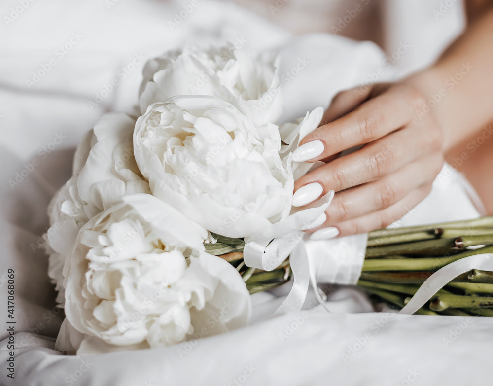 Fototapeta premium Girl bride holding a wedding bouquet of flowers