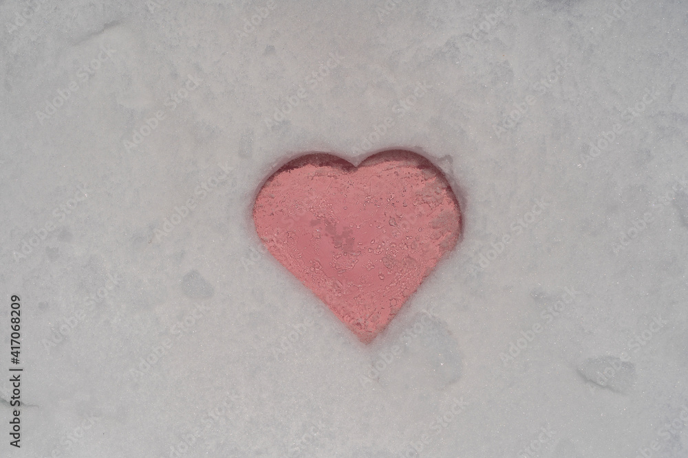 Pink heart shape on a white fresh snow in winter, close up Pink heart shape on a white fresh snow in winter, close up