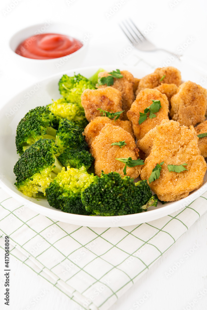 Chicken nuggets with vegetables, broccoli and ketchup on a white background Chicken nuggets with vegetables, broccoli and ketchup on a white background