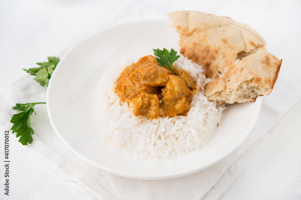 Chicken with rice in curry sauce-a traditional Indian dish on a white