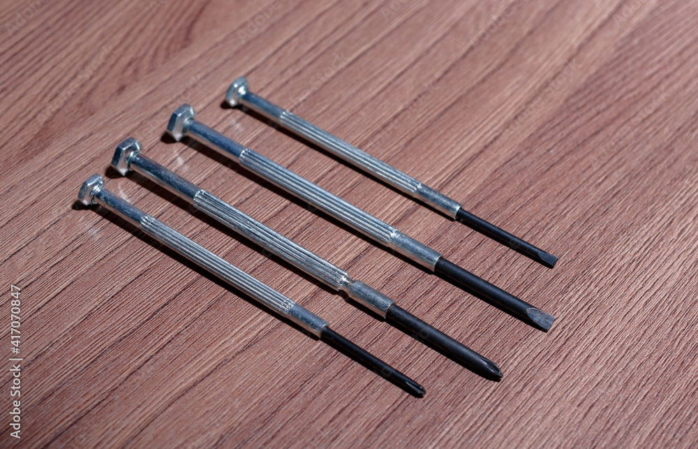 A set of magnetic screwdrivers for twisting and unscrewing screws and self-tapping screws on a wooden close-up A set of magnetic screwdrivers for twisting and unscrewing screws and self-tapping screws on a wooden close-up