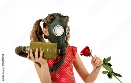 little girl in gas masks sniffing rose flower photo