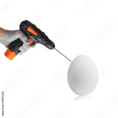 hand hold drill and drilled white chicken egg photo