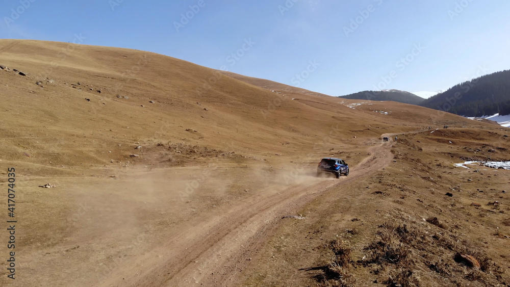 the car drives on the road through the desert. Aerial footage from drone the car drives on the road through the desert. Aerial footage from drone