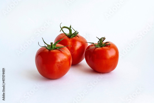 Three red tomatoes isolated on a white background