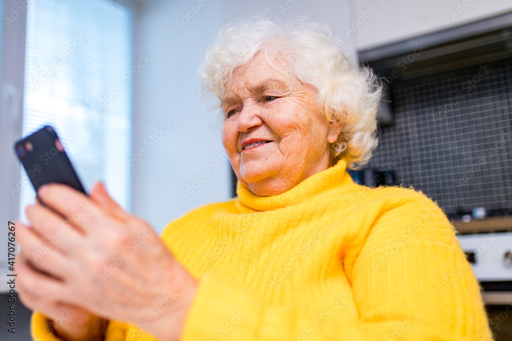 Portrait of old smiling lady looking at screen of mobile phone Portrait of old smiling lady looking at screen of mobile phone