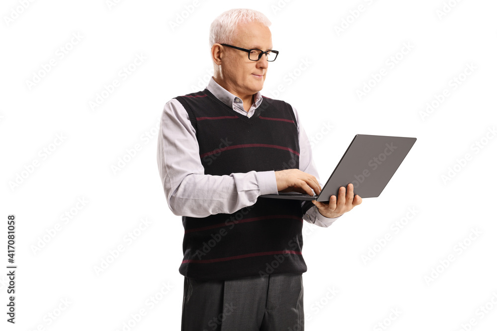 Mature man standing and working on a laptop computer Mature man standing and working on a laptop computer