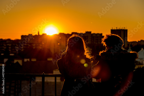 A couple is watching the sunset over the city from the observation deck in Warsaw, Poland (Lens Flair)