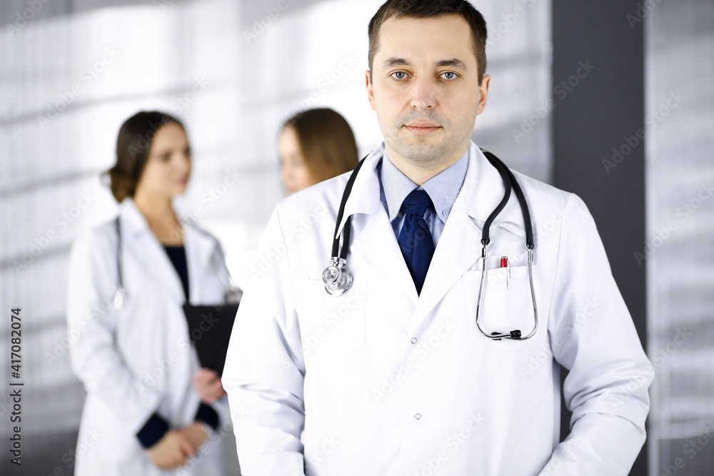 Professional middle aged doctor with a stethoscope at work with colleagues in a clinic. Perfect medical service in a hospital. Medicine and healthcare concept Professional middle aged doctor with a stethoscope at work with colleagues in a clinic. Perfect medical service in a hospital. Medicine and healthcare concept