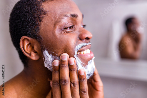 hispanic man put on foam on beard perfume lotion or skin care cream for sensitive skin