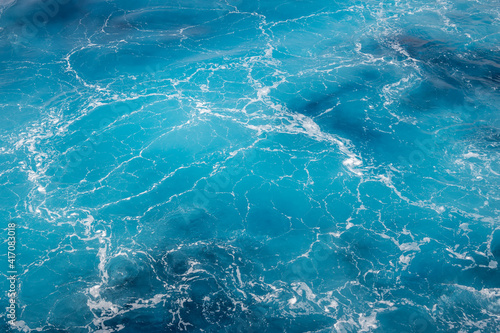 Natural background of blue foam sea water.