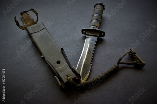 black military knife or dagger on black background