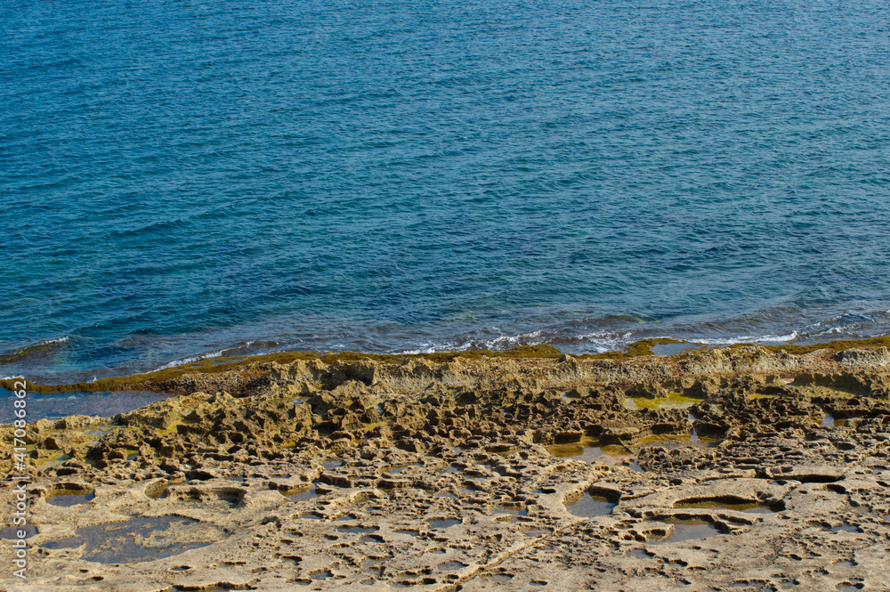 Sliema rocky beach in Malta. Beautiful blue mediterranean sea.