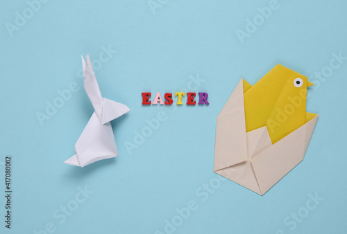 Origami rabbit and chicken, word easter on blue background. Easter, spring composition
