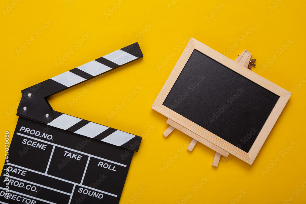 Movie clapper and Mini Empty chalk board with copy space on yellow background