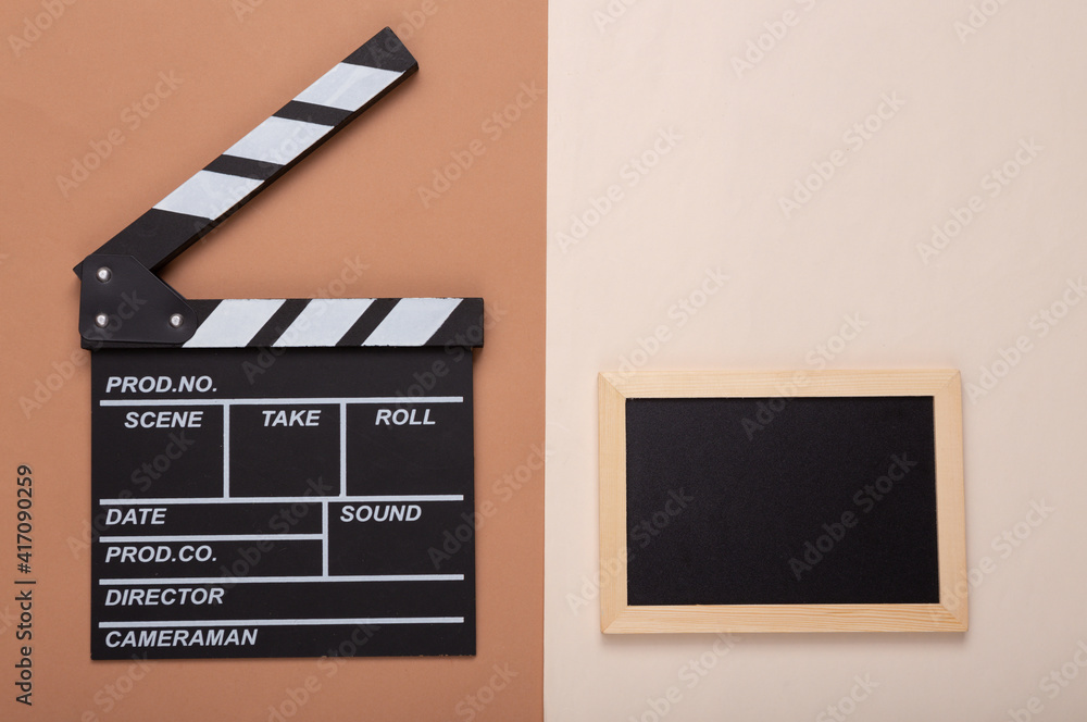 Movie clapper and Mini Empty chalk board with copy space on brown beige background