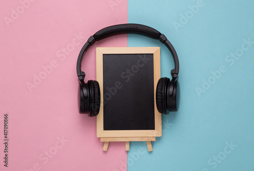 Empty chalk board with headphones on a pink blue background. Copy space