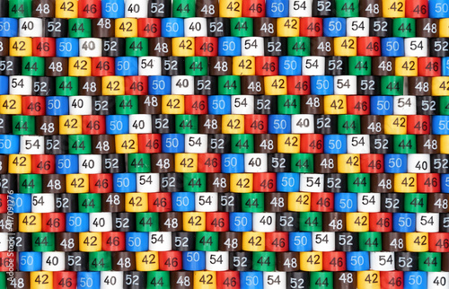 Background from multi-colored plastic tags of clothing sizes for a store.