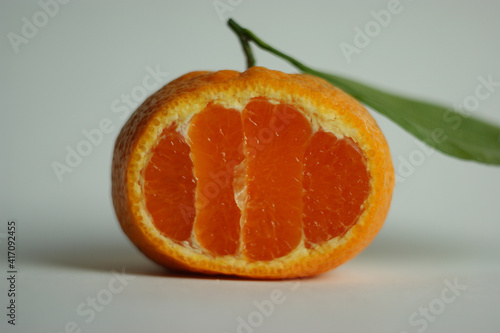 ripe and juicy tangerine (mandarin). fresh tangerine with leaf on white, closeup