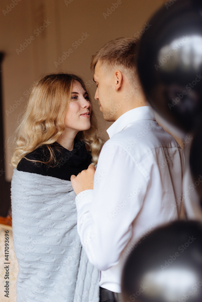 Fototapeta premium A young man and a woman embrace in a loft-style interior